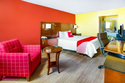 a hotel room with a bed and a red wall at OYO Hotel Jackson South I-55 in Jackson