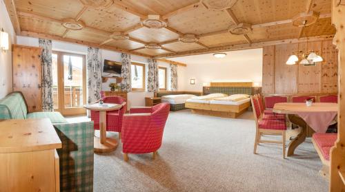 een woonkamer met een bed en een tafel en stoelen bij Landhotel Tirolerhof - Mai bis Mitte Juni kein Saunabetrieb in Oberau