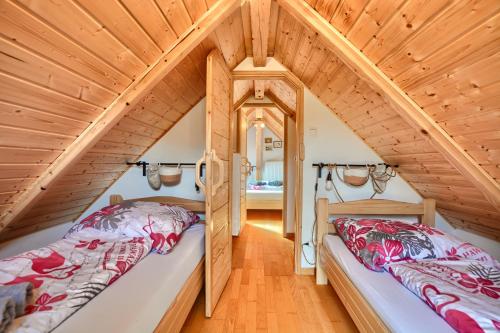 two beds in a attic room with wooden ceilings at Bieszczadzki Jeleń in Ustrzyki Dolne