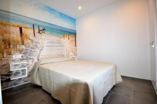 a bedroom with a painting of the beach at Apartamento La Ola in Conil de la Frontera