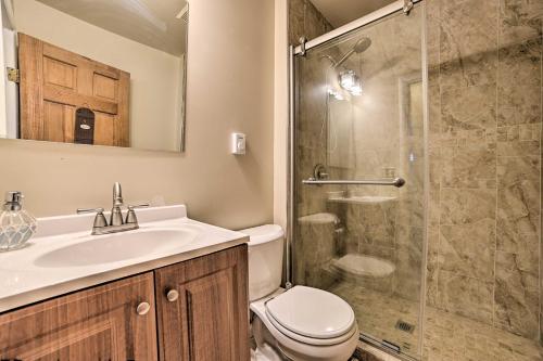 a bathroom with a toilet and a sink and a shower at Cozy Houghton Lake Heights Cottage with Private Yard in Houghton Lake