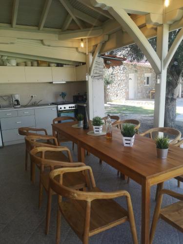 a dining room with a wooden table and chairs at Makis Nest Apart-Hotel in Vourvourou