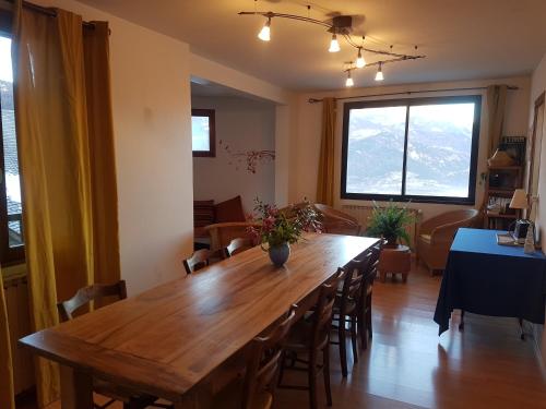 une salle à manger avec une grande table et des chaises en bois dans l'établissement La Maison de Joséphine, à Risoul