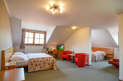a bedroom with two beds and a table and chairs at Hotel Galant Mikulov in Mikulov