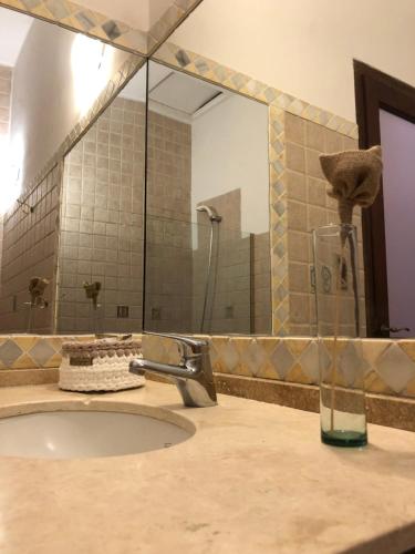 La salle de bains est pourvue d'un lavabo et d'un grand miroir. dans l'établissement Petit Deluxe Salta, à Salta