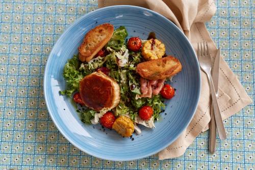 a blue plate with a salad with strawberries and toast at El Cid Country Club in Benidoleig