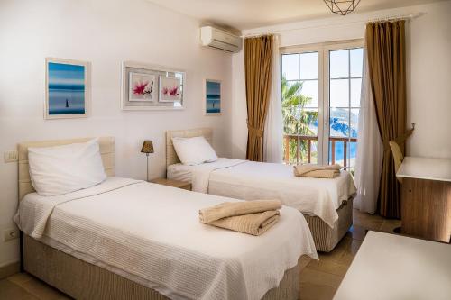 two beds in a room with a window at Villa Marlin in Kalkan