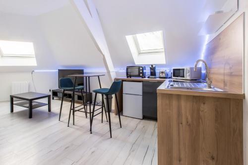 une cuisine avec des chaises et un comptoir avec un évier dans l'établissement Studio Paris, à Tourcoing