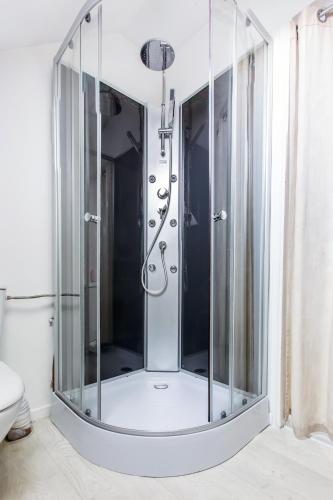 une douche avec une cabine en verre dans une salle de bain dans l'établissement Studio Paris, à Tourcoing