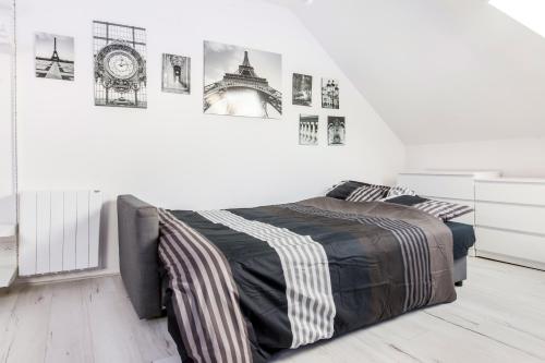 une chambre avec un lit et des tableaux au mur dans l'établissement Studio Paris, à Tourcoing