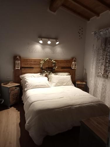 a bedroom with a large bed with white sheets at Serena Country home in Capranica