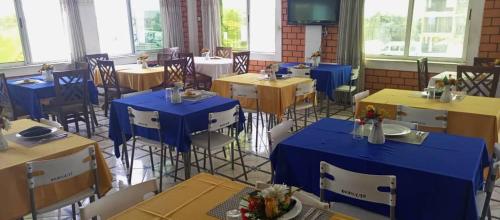 un comedor con mesas y sillas azules en RIDMA HOTEL, en Accra