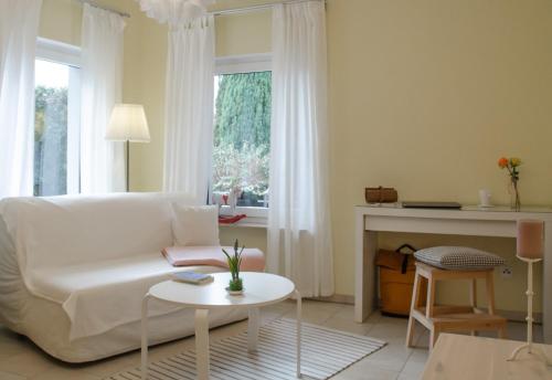 a living room with a white couch and a fireplace at Pension Horn Bautzen in Bautzen