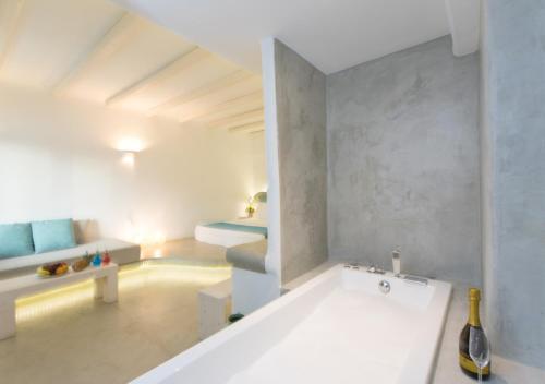 a white bathroom with a tub in a room at Princess Of Naxos in Naxos Chora