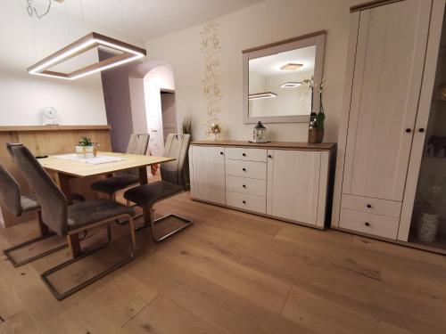 ein Esszimmer mit einem Holztisch und Stühlen in der Unterkunft Ferienwohnung und Pension Gürtler in Mohlsdorf