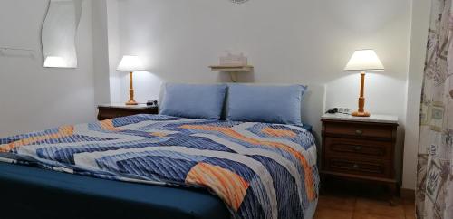 a bedroom with a blue bed with two lamps at Los Geranios n.25 in Icod de los Vinos