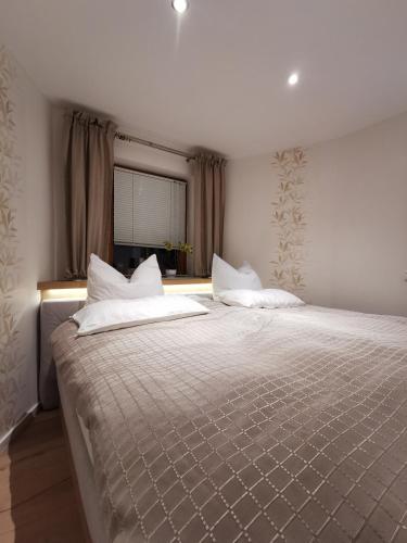 a bedroom with a large bed with white pillows at Ferienwohnung und Pension Gürtler in Mohlsdorf