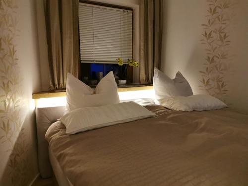 a bed with white pillows in a room with a window at Ferienwohnung und Pension Gürtler in Mohlsdorf