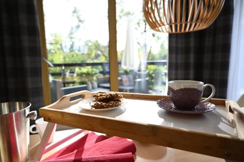 a table with two cups of coffee and a plate of food at Apartamenty u Harrego II Przy Stawie Spa klimatyzacja,balkon,sauna , balia, ogród,parking in Kudowa-Zdrój