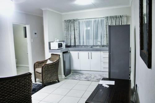 a kitchen with a table and chairs and a microwave at Maruleng Guest House in Hoedspruit