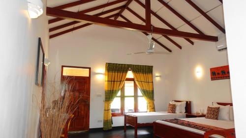 a room with two beds and a window at Regina Beach Bungalow in Trincomalee