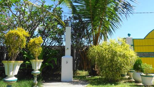 a white pole with some plants in a yard at Regina Beach Bungalow in Trincomalee