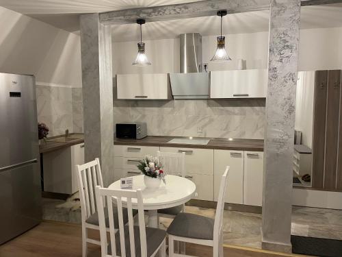a kitchen with a table and chairs and a refrigerator at Sofia Loft in Bistriţa