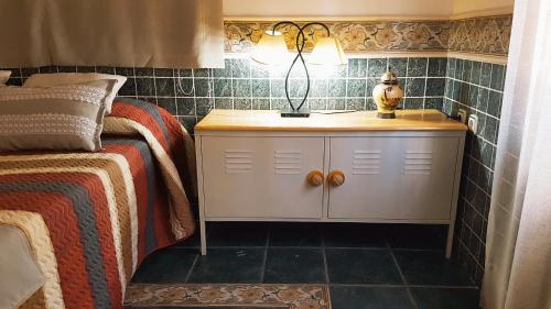 - une chambre avec un lit et une lampe sur une armoire dans l'établissement Casa Rural Finca Real De Niebla, à Niebla