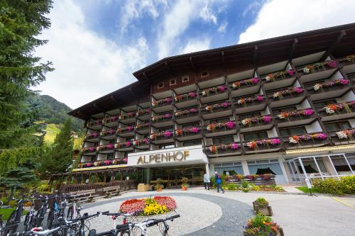 a large building with flowers in front of it at Hotel Alpenhof in Sankt Jakob in Defereggen