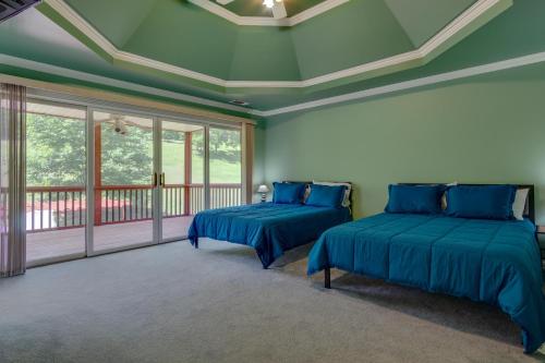 two beds in a room with green walls and windows at Country Cove in Brentwood