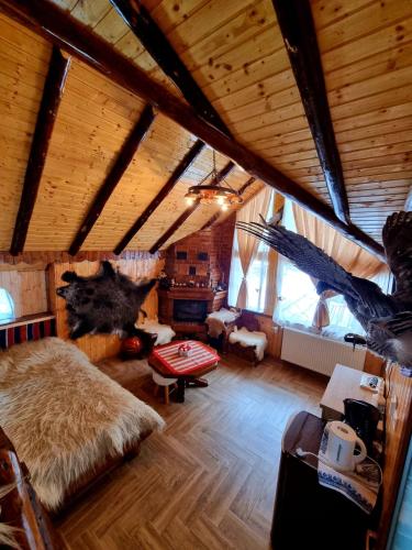 Habitación grande con cama grande en una habitación con techo de madera. en Căbănuța Cocoțată, en Rucăr