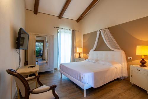 a bedroom with a bed and a tv and a chair at Ca Montiglio in Quagliuzzo