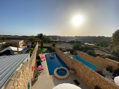a view of a swimming pool from the balcony of a house at Sunset Farmhouse in Għarb