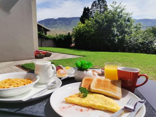 a breakfast table with toast and scrambled eggs and orange juice at The Raz in Harrismith