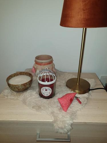 a table with a lamp and a basket and a lamp at La Mara Élo in Sart-lez-Spa