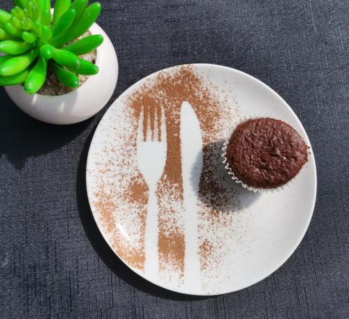 a plate with a fork and a cookie and a plant at The Raz in Harrismith