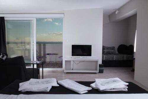 salon z telewizorem i białymi ręcznikami na łóżku w obiekcie My Home Garden w Stambule