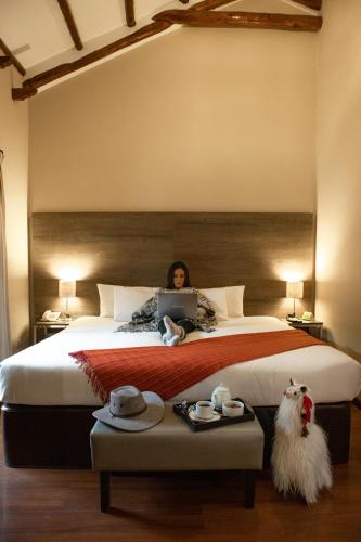 a woman laying on a bed with a laptop at Union Hotel Cusco in Cusco