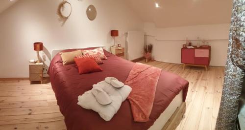 una camera da letto con un grande letto con lenzuola rosse e asciugamani di La Mara Élo a Sart-lez-Spa