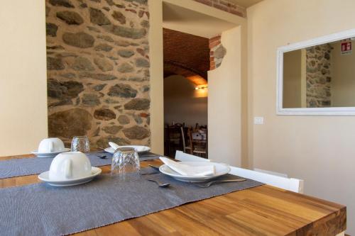 a dining room with a wooden table and a stone wall at Ca Montiglio in Quagliuzzo