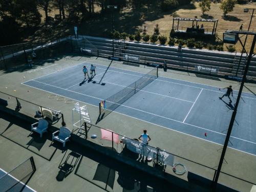a group of people playing tennis on a tennis court at Posta Natural in Tandil