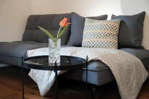 uma sala de estar com um sofá e um vaso de vidro sobre uma mesa em Großzügiges, stilvolles, charmantes Appartement in Salzburg by Fiorentino em Salzburgo