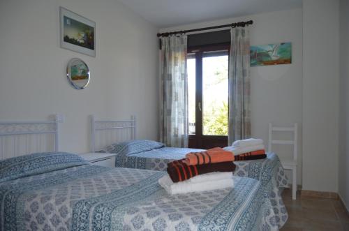 アヤモンテにあるCostaesuri Vacaciones "Casa Vista"のベッドルーム1室(ベッド2台、窓付)