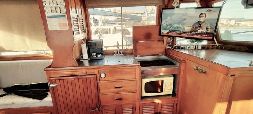 een keuken met een magnetron en een tv. bij Barco 12 mts centro Cangas in Cangas de Morrazo