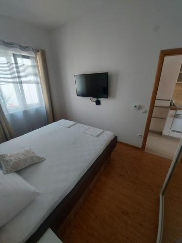 a bedroom with a bed and a flat screen tv at Apartmani Barka in Neum
