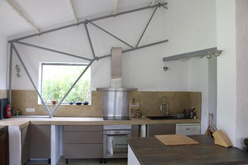 une cuisine avec une grande fenêtre et un comptoir de cuisine dans l'établissement Maison calme, 4ch/7pers, avec piscine à débordement, à Lussan