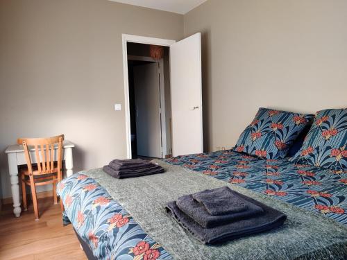 een slaapkamer met een bed met twee handdoeken erop bij Appartement du parc des thermes in Thonon-les-Bains