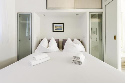 una camera da letto bianca con un grande letto bianco con cuscini bianchi di Apartments Villa Pina a Vodice