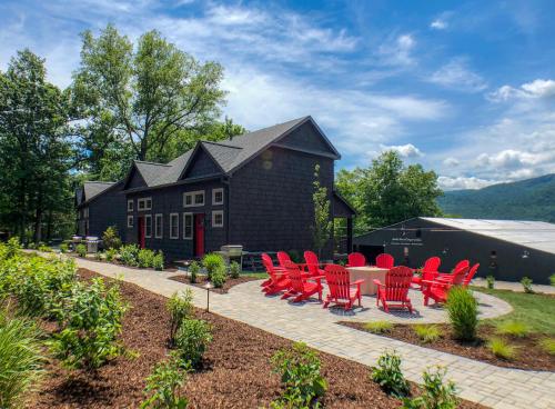 a group of red chairs and a table in front of a house at Lakeside Lodging in Lake George