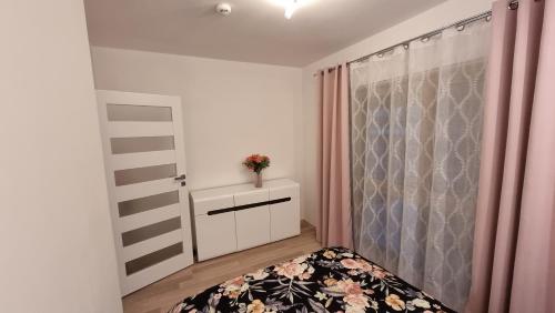a small bedroom with a bed and a window at Fala Bałtyku Apartament Nadmotławie in Gdańsk